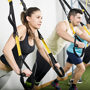 People at gym doing trx exercises at crossfit room