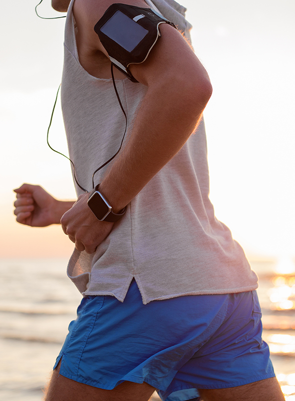 Man running with music player and smartwatch on his wrist