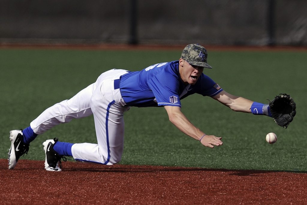 A baseball player reacts to a ball hit into the infield.