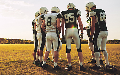 Football players discuss their plan before executing a play.