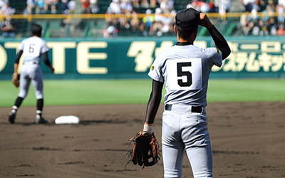 Baseball players watch as ball get hit out of the park.