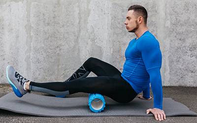 Man uses foam roller for recovery post workout.