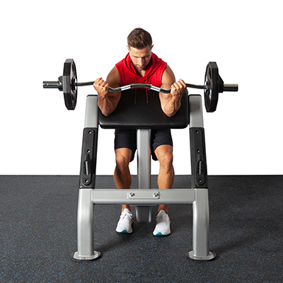 Man performs preacher curl using bent bar.