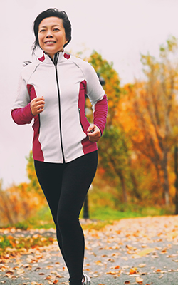 Woman runs dressed in appropriate cold weather training gear.