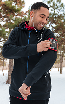 Man adjusts his music player before getting started with cold weather training.