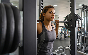 Female athlete prepares for a high intensity, low rep session at the squat rack.